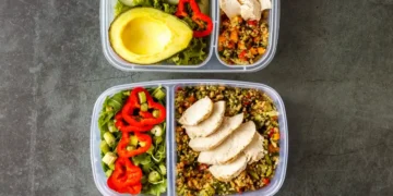 Marmitas fitness preparadas para o trabalho, com arroz, legumes e frango grelhado, oferecendo opções saudáveis.