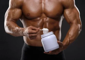 Pessoa praticando musculação e medindo creatina, em referência ao estudo que afirma que a creatina não aumenta a massa muscular.