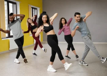Grupo de pessoas praticando dança em estúdio, destacando os benefícios físicos e mentais da dança como exercício.