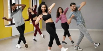 Grupo de pessoas praticando dança em estúdio, destacando os benefícios físicos e mentais da dança como exercício.