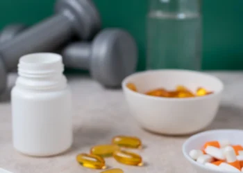 "Suplementos para a saúde cerebral, incluindo cápsulas, pó e frascos, ao lado de halteres."