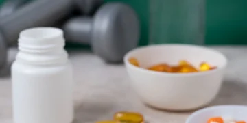 "Suplementos para a saúde cerebral, incluindo cápsulas, pó e frascos, ao lado de halteres."