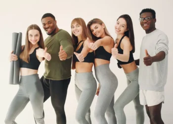 Grupo de jovens com roupas esportivas sorrindo e mostrando positividade após uma prática de exercícios.