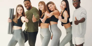 Grupo de jovens com roupas esportivas sorrindo e mostrando positividade após uma prática de exercícios.