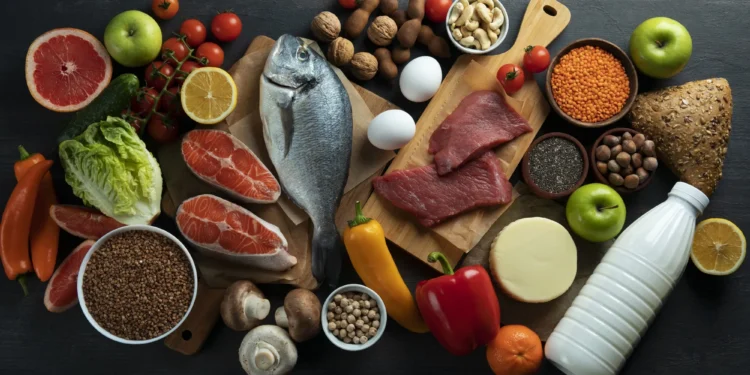 Diversos alimentos saudáveis, incluindo frutas, vegetais, peixe, carne magra, grãos e laticínios, organizados em uma composição visual atraente.