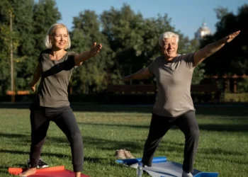 Casal maduro praticando exercício físico ao ar livre em um parque ensolarado