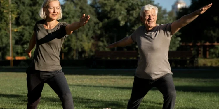 Casal maduro praticando exercício físico ao ar livre em um parque ensolarado