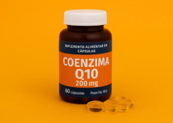 Frasco de suplemento de Coenzima Q10 com cápsulas sobre fundo laranja vibrante.