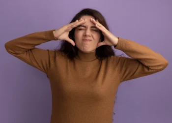 Mulher com expressão de frustração, com as mãos nas têmporas, demostrando ansiedade.