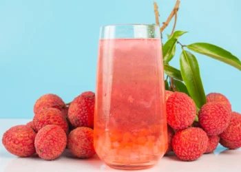 Copo de chá de lichia ao lado de frutas frescas