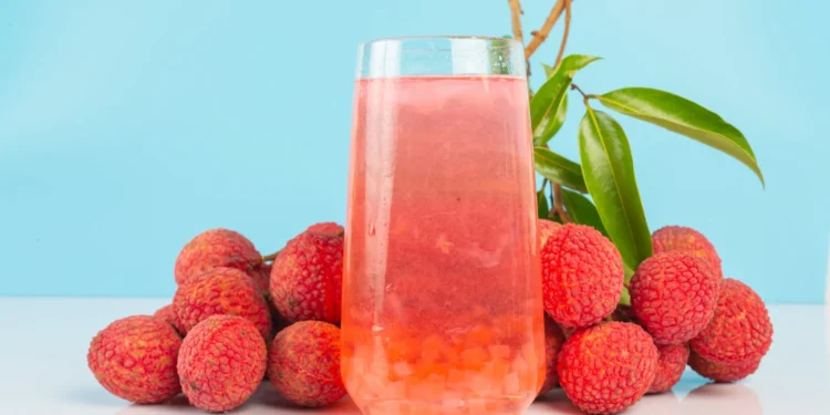 Copo de chá de lichia ao lado de frutas frescas