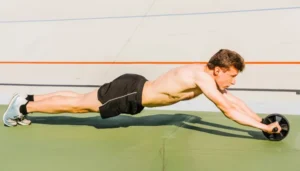 Homem realizando exercício avançado com roda abdominal ao ar livre