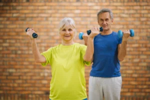 Idosos praticando exercício com halteres para manter a força muscular