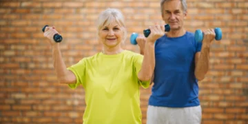 Idosos praticando exercício com halteres para manter a força muscular