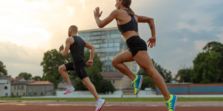 Corredores em movimento, aprimorando seu desempenho com exercícios de fortalecimento na pista.