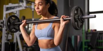 Mulher treinando barra para ganho de massa muscular e perda de gordura