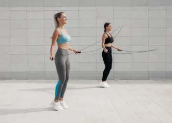 Duas mulheres praticando exercício de pular corda ao ar livre, destacando benefícios para o condicionamento físico.