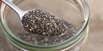 Sementes de chia em colher sobre pote de vidro, alimento saudável para dietas equilibradas