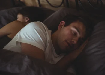 Casal descansando profundamente na cama, ilustrando a importância de um sono saudável para a qualidade de vida.