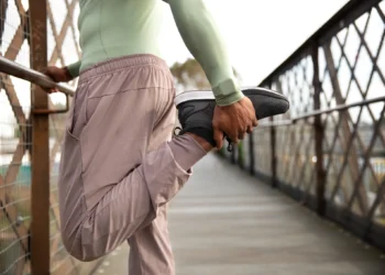 Homem fazendo alongamento diário em ponte ao ar livre