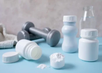 Recipientes e halteres representando o consumo de creatina para melhorar a memória.