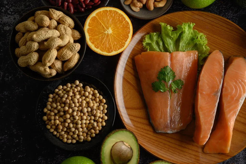 Prato com salmão, legumes, frutas e nozes, exemplificando alimentos ricos em nutrientes para uma dieta mediterrânea.