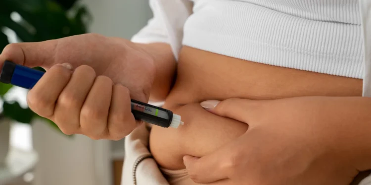 Mulher utilizando caneta para emagrecimento em sua barriga