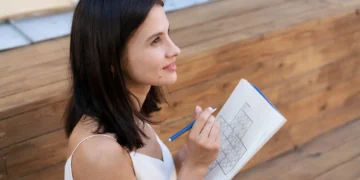 Mulher concentrada resolvendo um jogo de sudoku, exercitando o cérebro para melhorar o desempenho mental durante o dia.