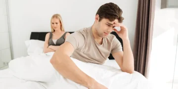 Homem e mulher em um momento de desconforto no quarto, representando a relação com baixa libido.