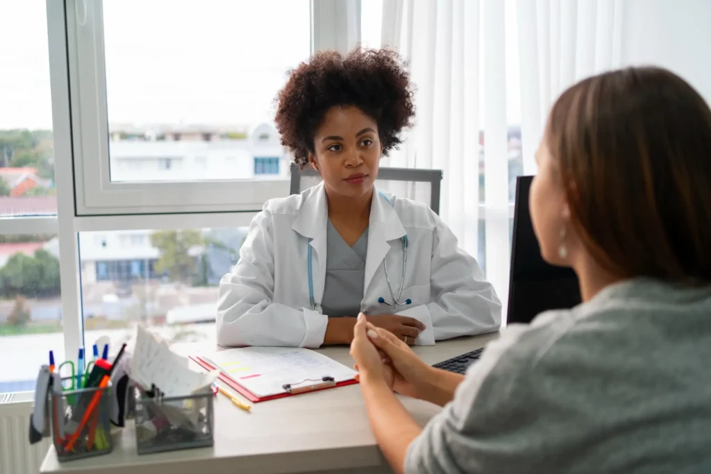 Profissional de saúde ouvindo paciente durante consulta médica sobre saúde emocional e controle alimentar.