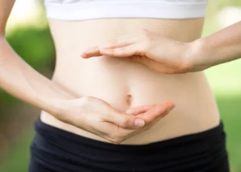 Mulher mostrando o cuidado com o intestino, simbolizando a importância da saúde intestinal para uma imunidade forte.