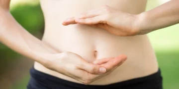 Mulher mostrando o cuidado com o intestino, simbolizando a importância da saúde intestinal para uma imunidade forte.