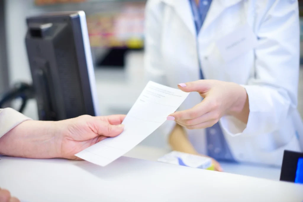 Paciente apresentando receita médica em farmácia para comprar caneta emagrecedora conforme exigido pela Anvisa.