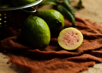 Goiaba fresca cortada, com casca verde e interior rosa, ideal para turbinar a sua ingestão diária de proteínas.