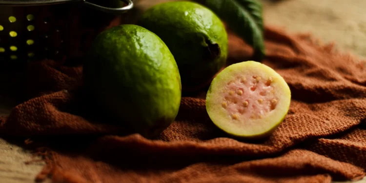 Goiaba fresca cortada, com casca verde e interior rosa, ideal para turbinar a sua ingestão diária de proteínas.